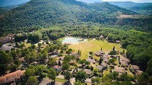 Ein Wohngebiet mit Häusern, einem zentralen, runden Park und sanften Hügeln.