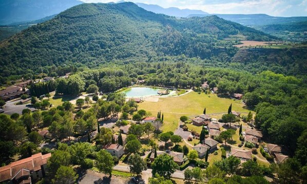 A residential area with houses, a central circular park, and surrounding hills. - Villa by Lake With Pyrenees Views (Quillan)