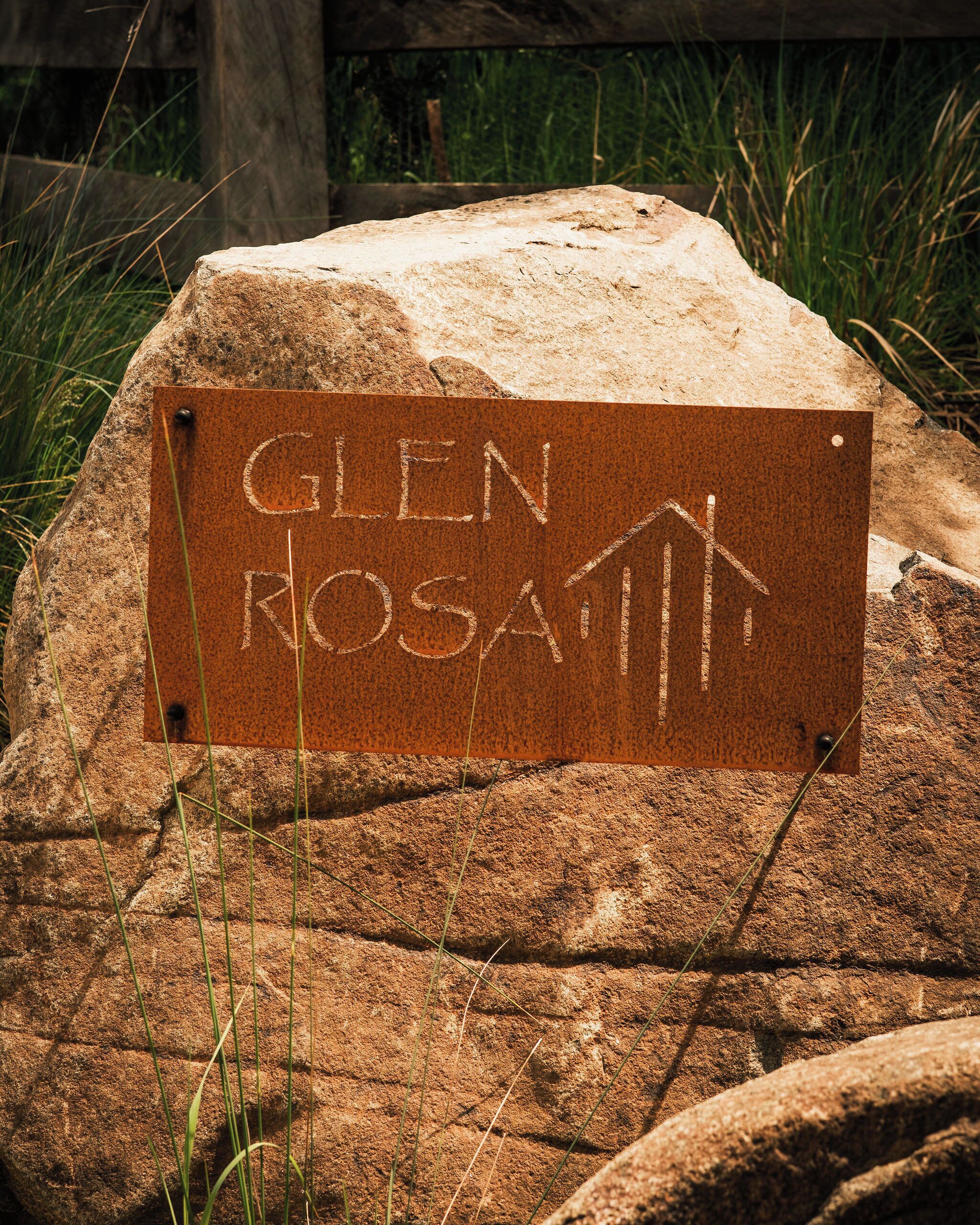 A sign on a rock with the text "GLEN ROSATI" and an arrow pointing upwards.