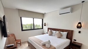 Une chambre d’hôtel moderne équipée d’un grand lit, d’un bureau, d’une chaise et d’un téléviseur.