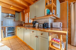 Une cuisine avec des armoires en bois, un plan de travail, une cuisinière et un four à micro-ondes.