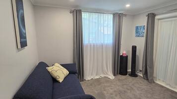 A room with a bed, a punching bag, and a window with curtains.