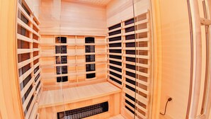 En bastu med väggar och bänkar av trä, ett ventilationssystem och en metalldörr.