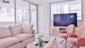 Ett modernt vardagsrum med en soffa, en tv och en fåtölj.