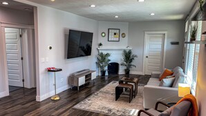 A modern living room with a flat-screen TV, a fireplace, and a cozy seating area. - Vibrant 4-Bed Perry District Unit: Full Kitchen, Outdoor Living – Groups' Dream! (Spokane)