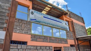 A building with a sign for 'Prestige Guest House' offering bed and breakfast, furnished rooms, and a 24-hour army room. - Prestige Guest House Karatina (Karatina)