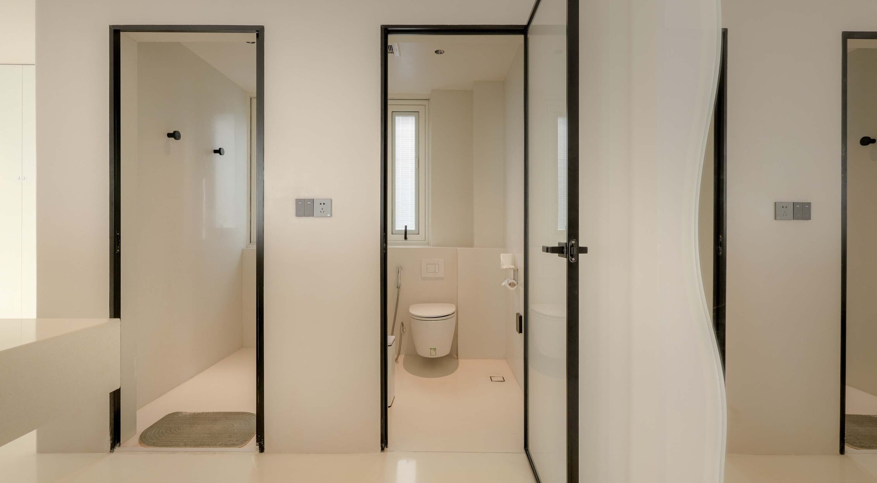 A modern bathroom with a toilet, shower, and sink.