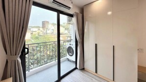 Un appartamento moderno con balcone, condizionatore, lavatrice e porta scorrevole.