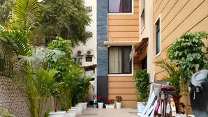 Une cour intérieure agrémentée de plantes en pot, un vélo et un bâtiment au design moderne.