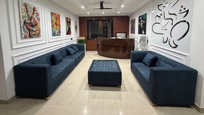 Un espace d’accueil comprenant deux canapés, un comptoir de réception et des œuvres d’art accrochées aux murs.