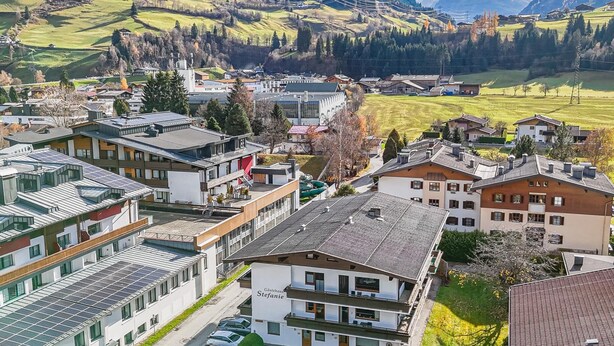 Un hotel moderno con techo plano, paneles solares y vistas al campo circundante.