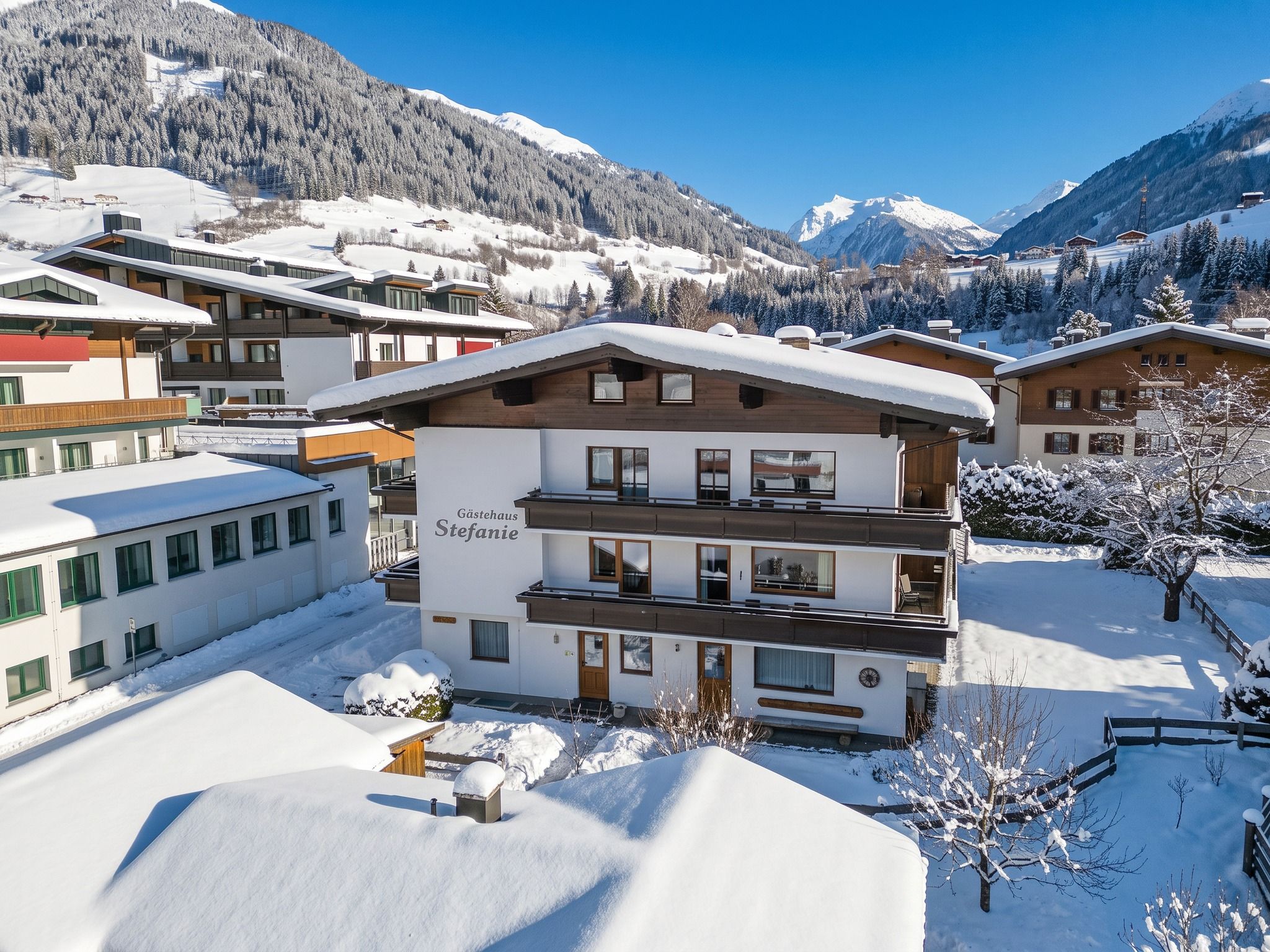 Un hôtel à plusieurs étages, avec un paysage enneigé et des montagnes en arrière-plan.