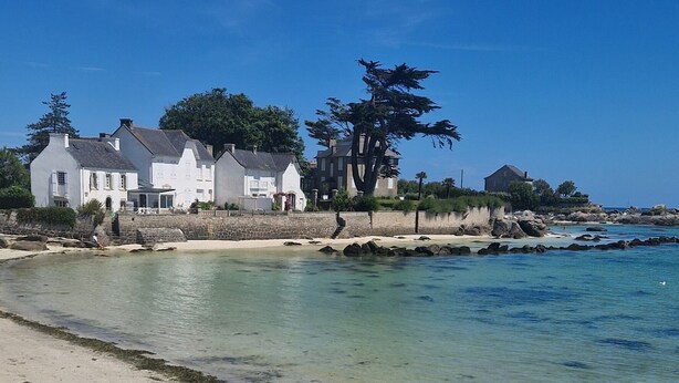 A beach with clear water, sandy shore, and white buildings in the background. - The house West side, SPA, Sea at 80 meters (Plounéour-Brignogan-plages)