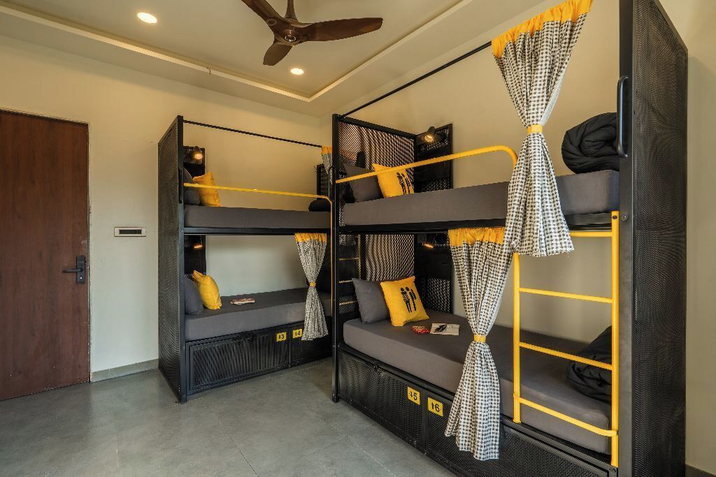 A room with bunk beds, a ceiling fan, and a door.