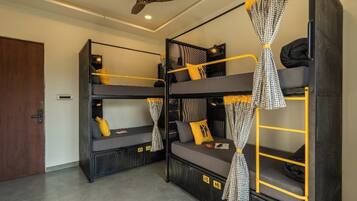 A room with bunk beds, a ceiling fan, and a door.