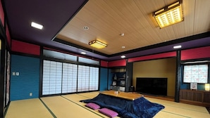 A tatami mat room with a low wooden table, cushions, and a television. - Kujiranoonaka (Yamanakako)