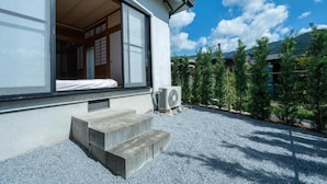 A traditional Japanese house with a sliding door, a concrete staircase, and a gravel driveway. - SAKURATARO MOMIJIJIRO NO MIYAKO (Asakura)