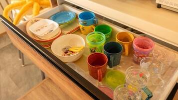 Una bandeja con tazas y recipientes de colores variados, presumiblemente para servir té o café.
