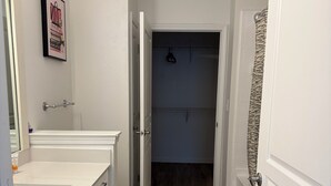 A bathroom with a white sink, toilet, and mirror. There is a towel rack and a shower curtain. - Universal Kids Resort Frisco Cozy 2-bedroom apartment with pool and gym access (Frisco)