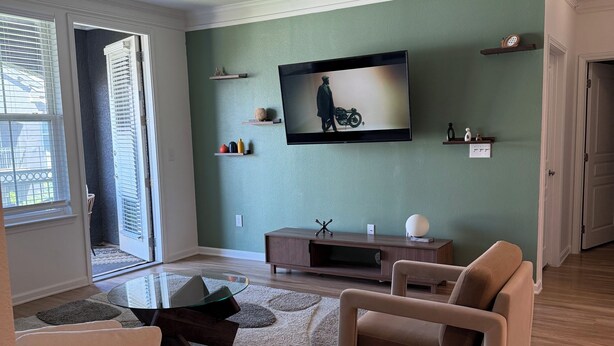 A living room with a flat-screen TV, a sofa, a coffee table, and a fireplace. - Universal Kids Resort Frisco Cozy 2-bedroom apartment with pool and gym access (Frisco)