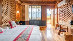 Una stanza in legno con un letto, una scrivania e una finestra vista.