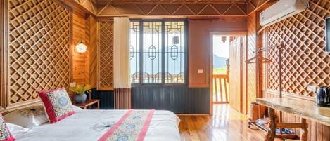 Una habitación de madera con una cama, un escritorio y una ventana con vistas.