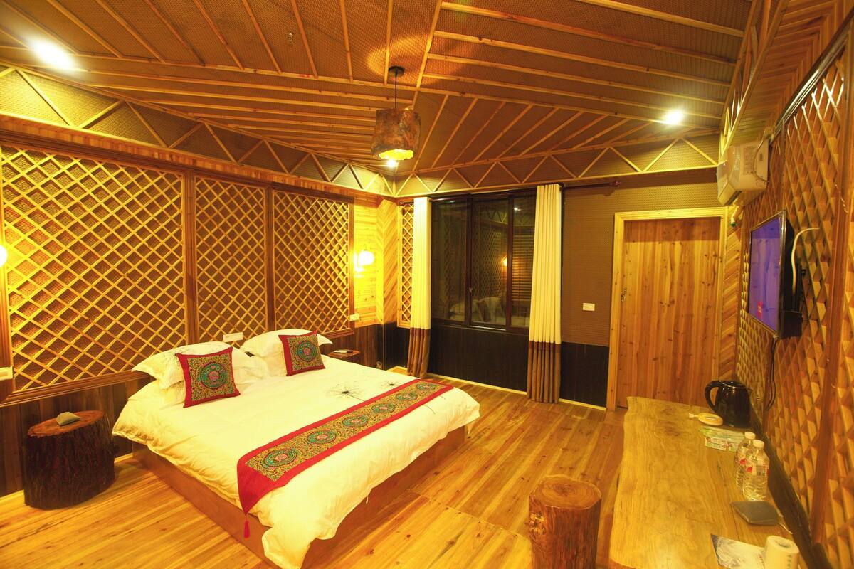 Dormitorio de estilo rústico con cama, mesitas de noche y suelo de madera.