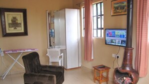 Ein Wohnzimmer mit einer Couch, einem Fernseher, einem Kamin und einem Kühlschrank.