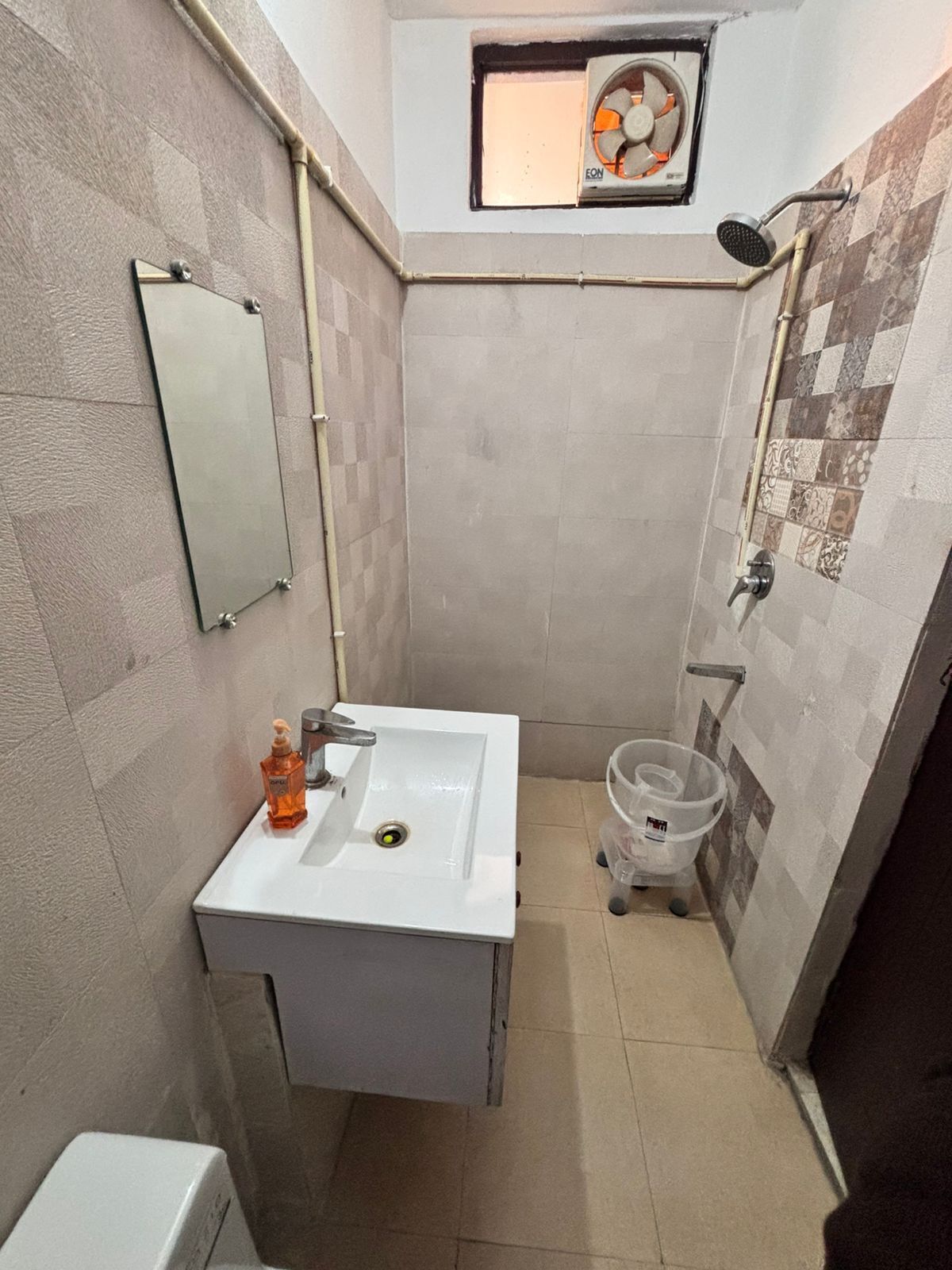 Un bagno piccolo con un lavandino bianco, uno specchio, una doccia e un water.