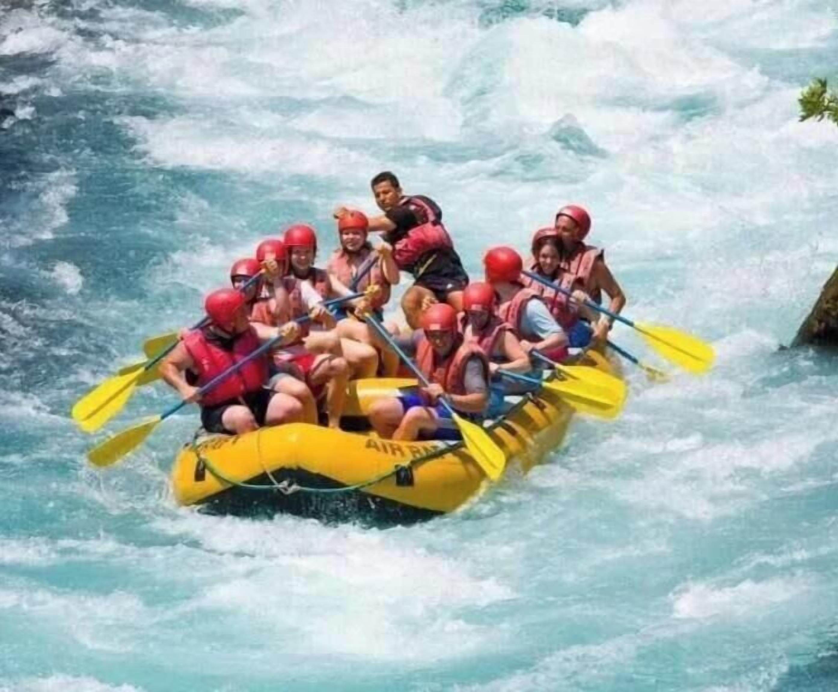 Un grupo de personas en un bote amarillo deslizándose por un río.