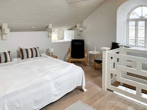 A bedroom with a bed, a chair, a small table, and a window. - 4 Person Holiday Home in Morbylanga (Morbylanga)