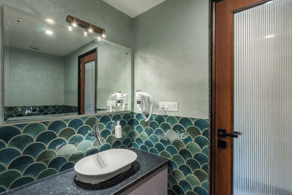 Une salle de bain avec un lavabo rond, un miroir et une douche.