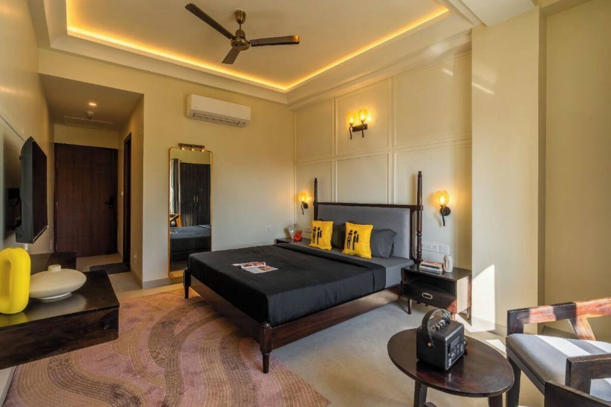 A modern bedroom with a large bed, bedside tables, a ceiling fan, and a TV.