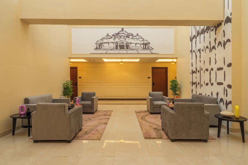 A lobby with grey sofas, a reception desk, and a large wall mural.