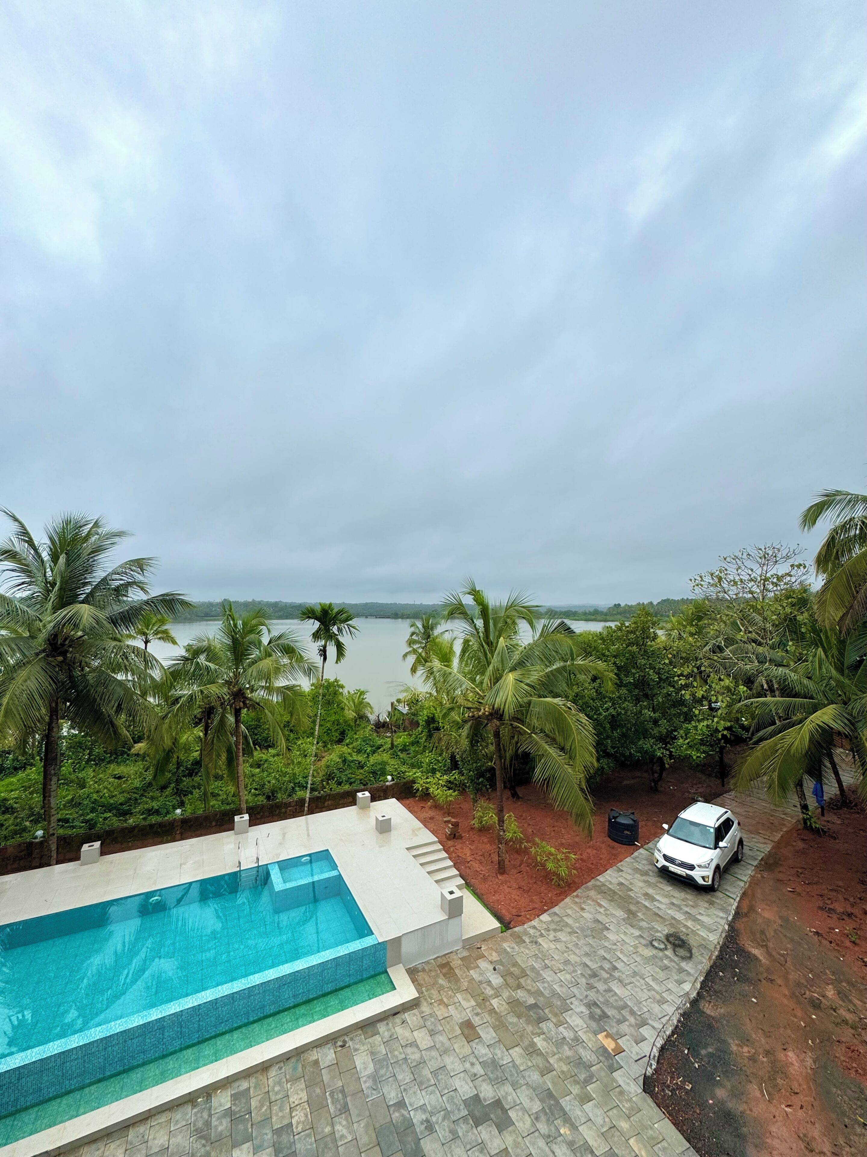 A swimming pool with a view of a lake and palm trees.