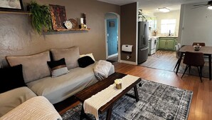 Un salón con un sofá, una mesa de centro y una alfombra estampada.