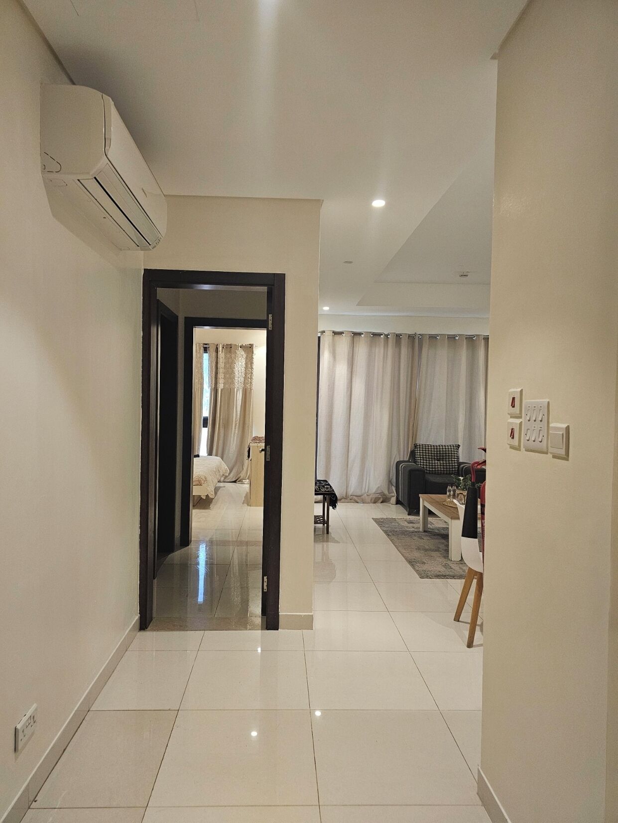 Un hall d’entrée spacieux au design moderne, qui donne accès à une chambre et à un espace de vie.