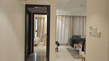 Un hall d’entrée spacieux au design moderne, qui donne accès à une chambre et à un espace de vie.
