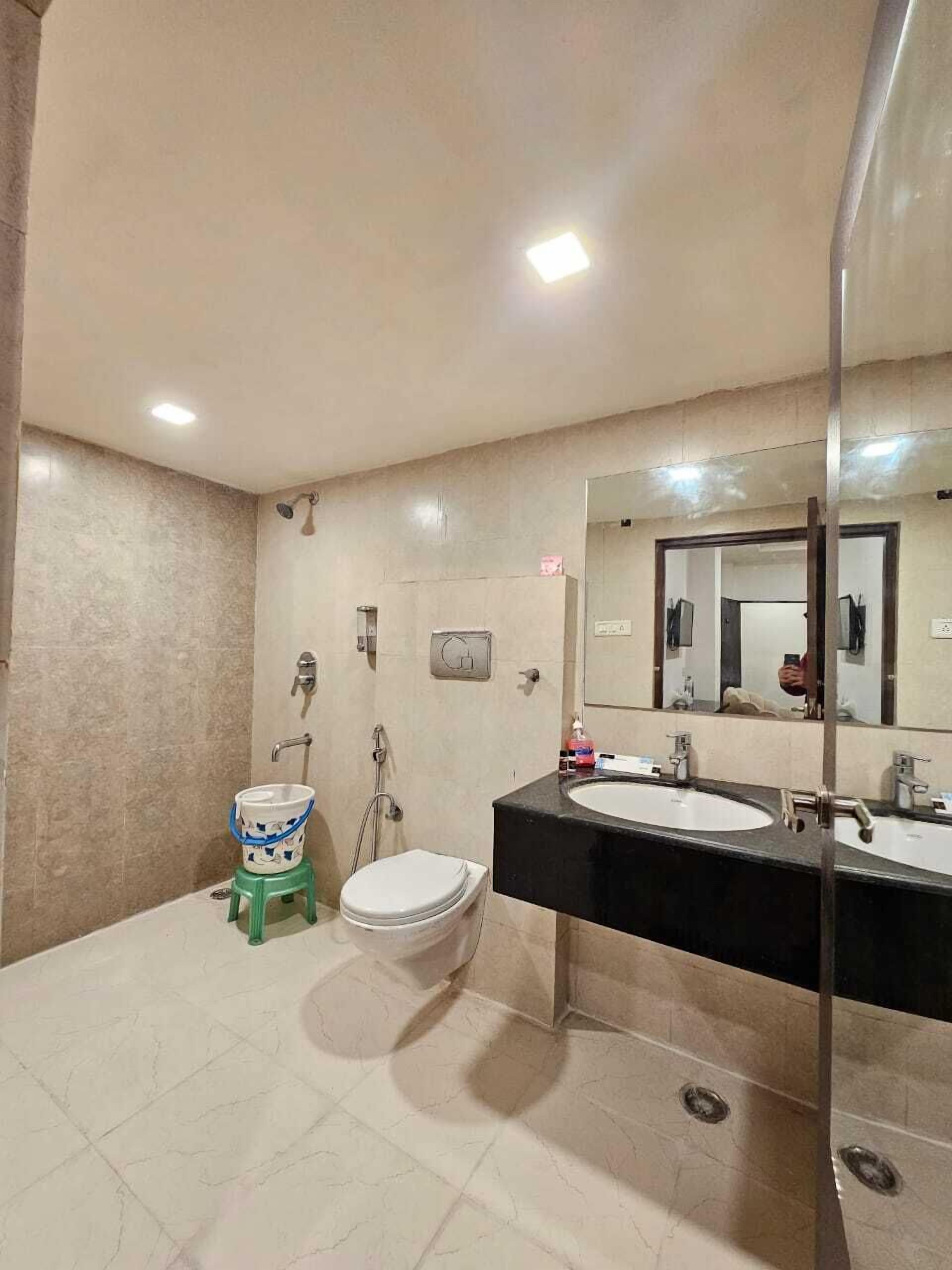 A bathroom with two sinks, a toilet, and a shower.