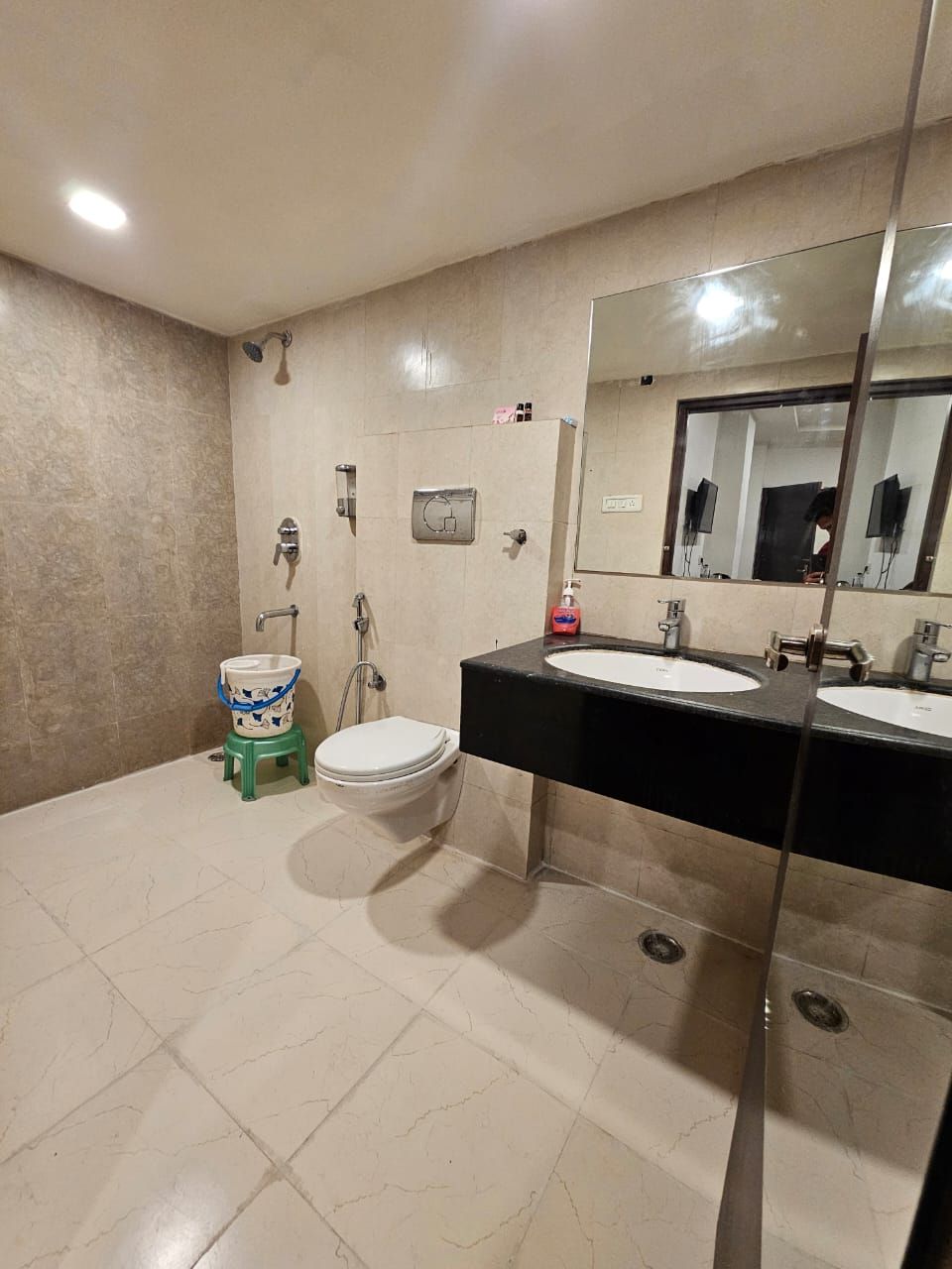 A bathroom with two sinks, a toilet, and a shower.