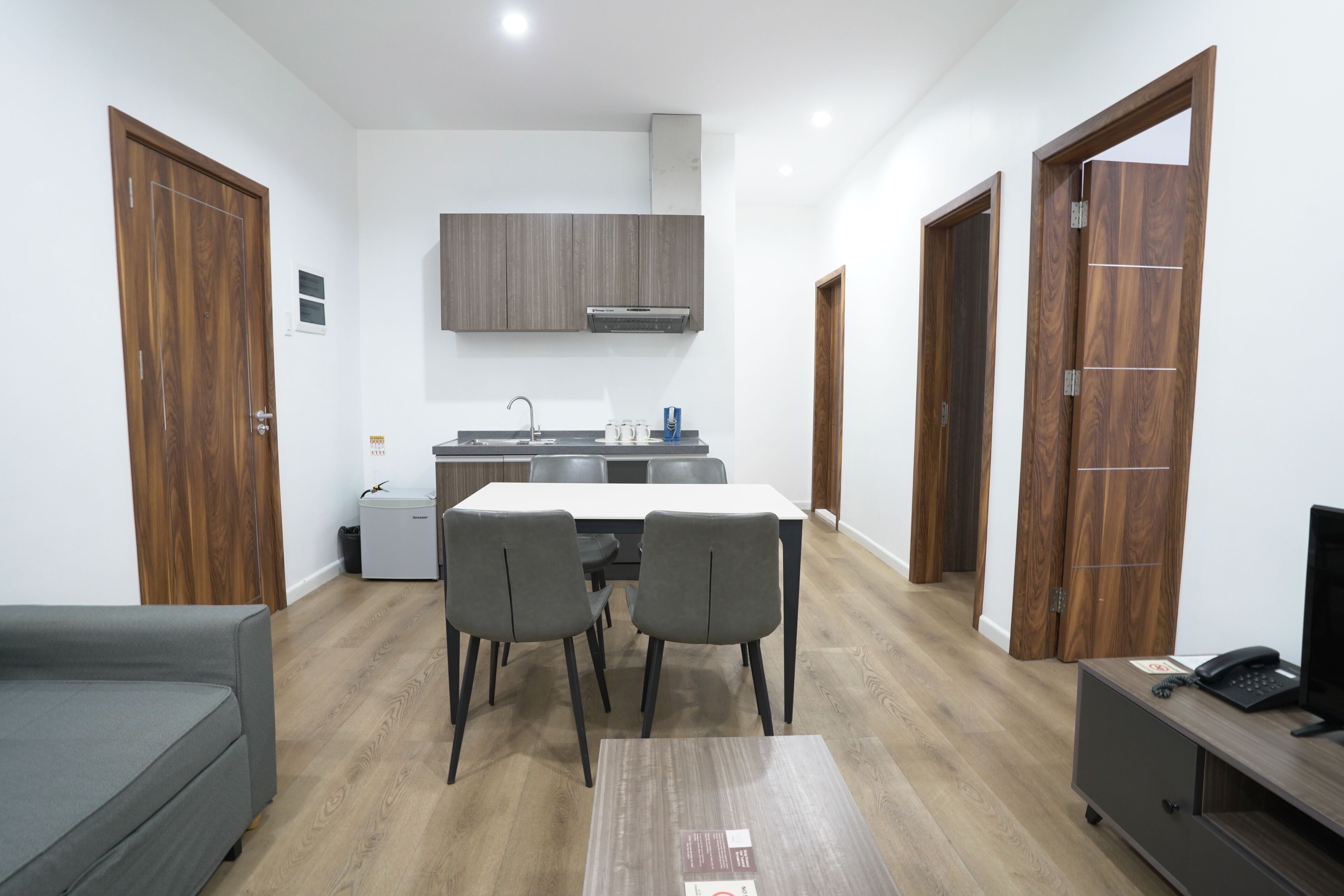 A compact living space with a kitchenette, dining area, and a small seating area.