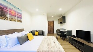 Ein modernes Hotelzimmer mit Bett, Schreibtisch, Fernseher und einem Bild an der Wand.