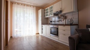 A modern kitchen with white cabinets, a built-in oven, and a coffee machine. - Apartments Slavek (Jastrebarsko)