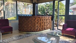 A room with two purple sofas, a glass coffee table, and a wooden log wall. - MJ FUNCITY WATER PARK &RESORT (Bakshi Ka Talab)