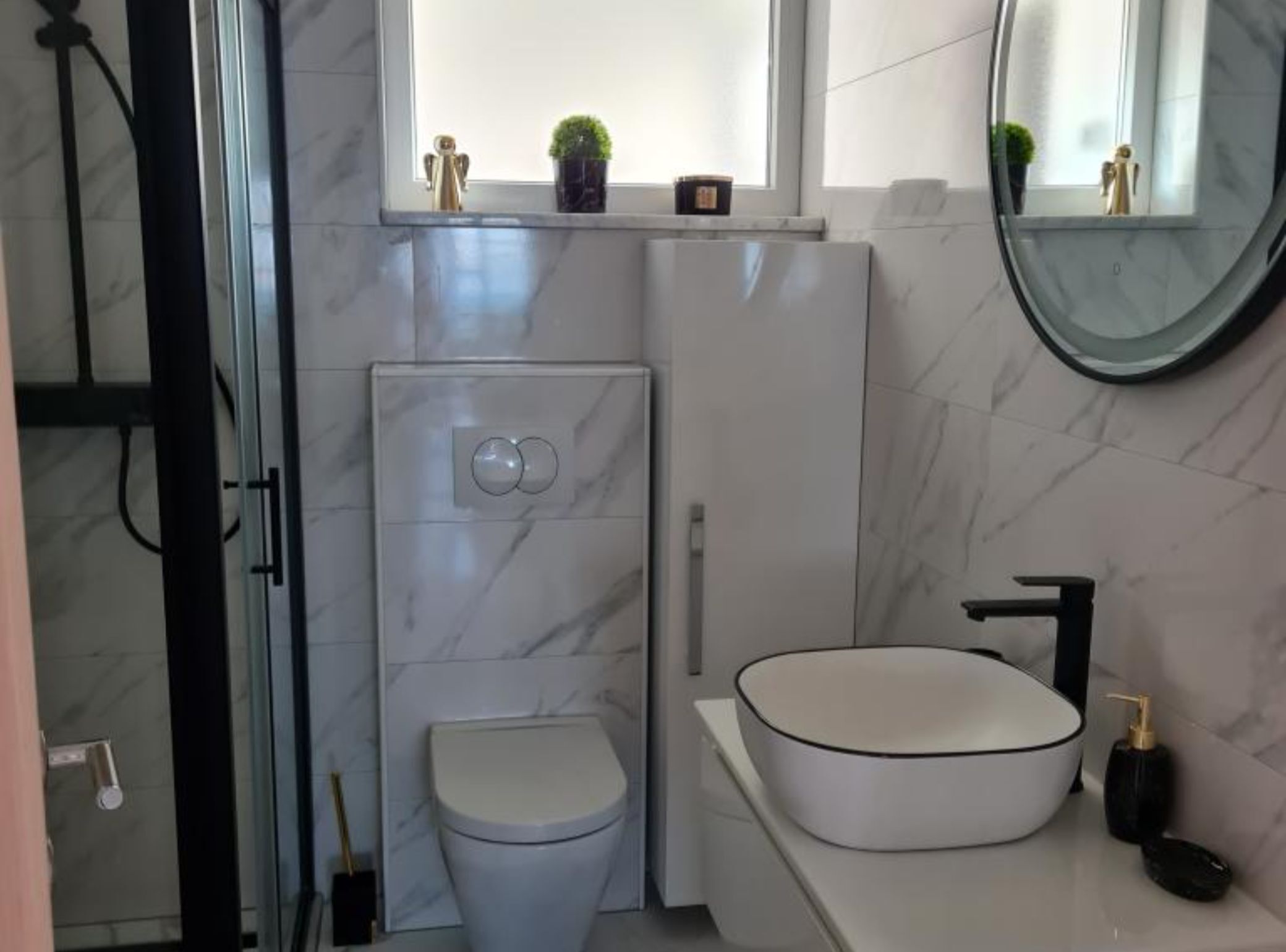 A modern bathroom with a toilet, bidet, and sink.