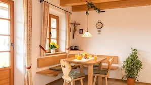 A cozy dining area with a wooden table, benches, and a potted plant. - Vacation apartment Anastasia (Chieming)