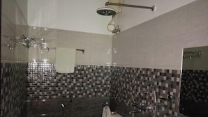 Une salle de bain avec une douche, des toilettes et un porte-serviettes.