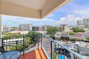 A balcony with a view of a cityscape, including buildings and solar panels. - Top Floor Tropical Escape | Pool | King Bed | Balcony (Darwin City)