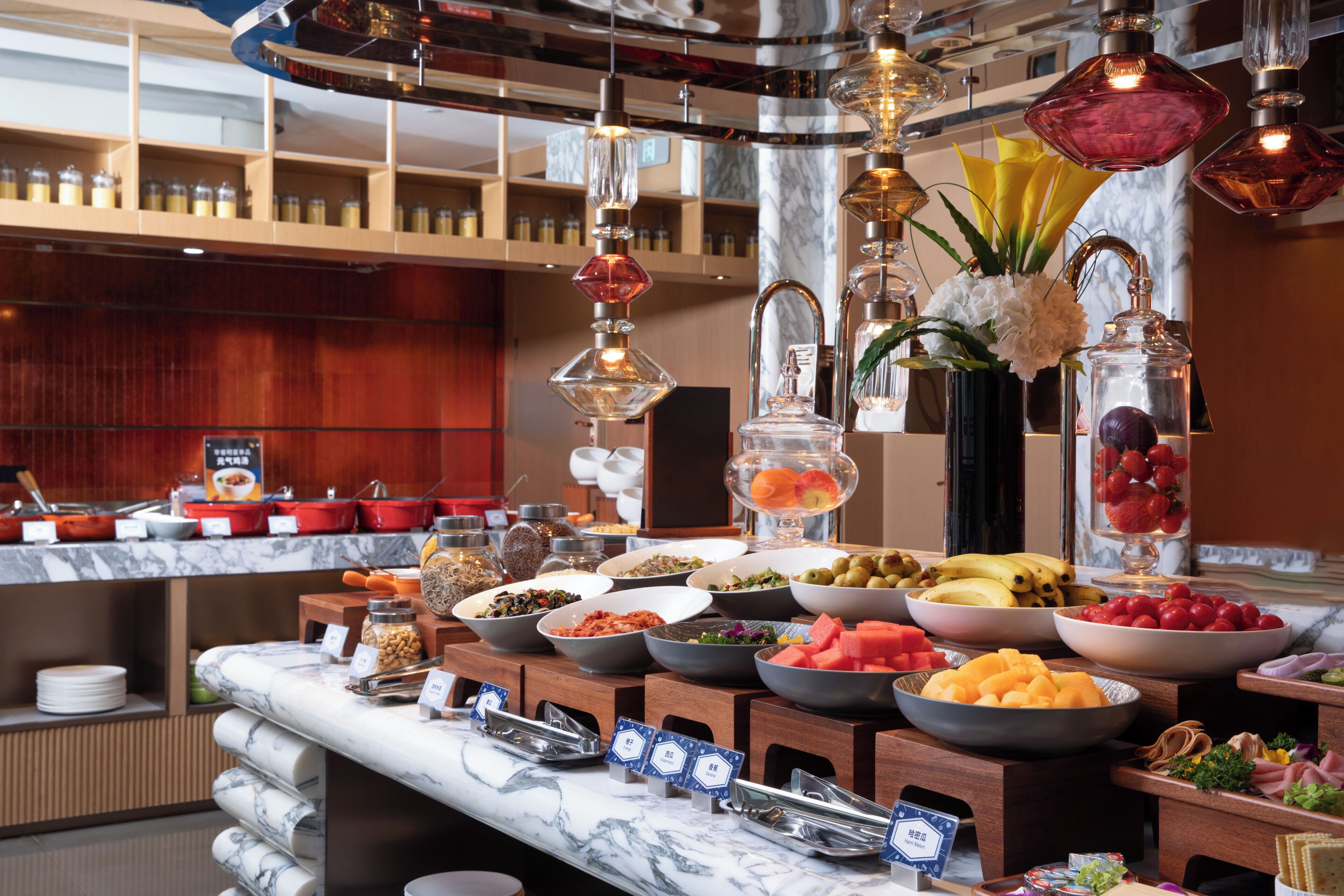 A buffet with various food items and a marble countertop.