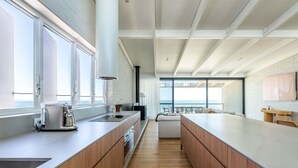 Uma cozinha moderna com uma bancada comprida, armários de madeira e vista para o exterior.